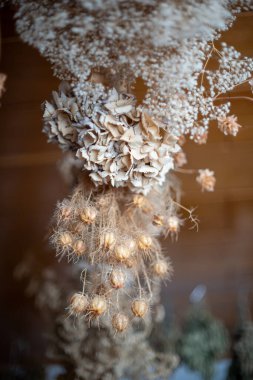 Çok katmanlı kurutulmuş çiçeklerin detaylı dikey görüntüsü. Görüntü farklı dokulardan oluşur, yukardaki narin bebek nefesinden ortadaki büyük kağıt çiçeklere ve karmaşık, dikenli tohumlara kadar..