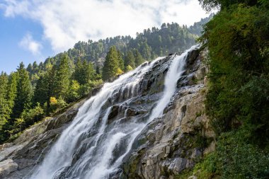 Grawa Şelalesi olarak bilinen güçlü bir şelale dalgası Avusturya 'nın Stubai Vadisi' ndeki dik ve kayalık bir uçurumdan yuvarlanır. Su koyu, pürüzlü kayalar ve yemyeşil ve sarı yapraklarla çarpıcı bir kontrast yaratır..