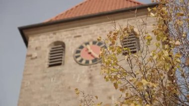 Altın Sonbahar Yaprakları 'nın çerçevelediği Kırmızı Çatı ve Saatli Kırsal Taş Kilise Kulesi' nin Yakın Çekimi