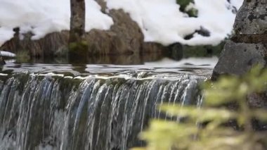 Bir Küçük Şelale Şelalesinin Ayrıntılı Yakın Çekimi, Uzaktan Karlı Manzara Yansımaları ve Doğal Çerçeveler Aralıksız Su Akışı