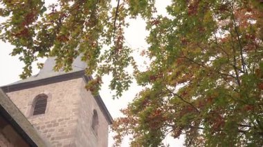 Kırsal Avrupa 'da Yeşil ve Üzümlü Sonbahar Yaprakları Altında Çerçevelenen Eski Taş Kilisenin Yakın Çekimi