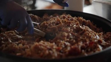 Şefin eldivenli ellerinin bir parça sıcak pita ekmeğini doldurmak için maşa kullanırken çekilmiş cömert bir porsiyon taze pişmiş domuz eti veya kebap eti.