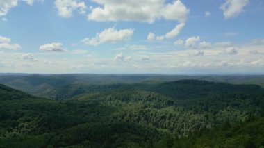 Sinema robotu, yoğun, yeşil bir orman ve dağ vadisinde beyaz bulutlu güzel mavi bir gökyüzünün altında çekildiğini gösteriyor. Çarpıcı bir doğa ve seyahat videosu..