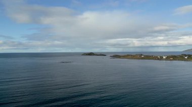 Lofoten Adaları 'ndaki sakin bir sahil köyü. Kayalık bir yarımadada beyaz ve kırmızı evler. Etrafı engin ve sakin sularla çevrili. Uzaktaki görkemli dağlarla..