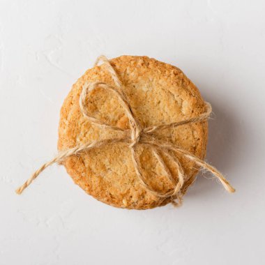 Oatmeal cookies are tied with craft thread on a white background. Healthy food for breakfast or a snack. Top view.