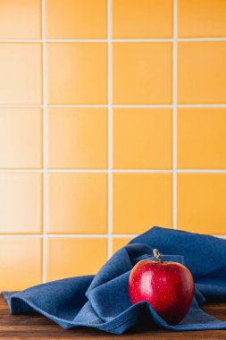 Ahşap bir masada mavi bir havlunun üzerindeki kırmızı elma. Kopya alanı olan taze meyvenin kenar görünümü.