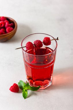 Arka plandaki bardakta ahududu içeceği var. Böğürtlen limonatası. Yan görünüm.