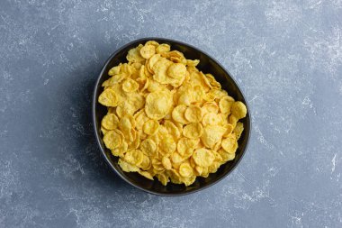 Mavi arka planda siyah kasede mısır gevreği.