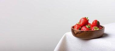 Tahta kasede fotokopi alanı olan taze çilekler. Beyaz masa örtüsü üzerinde tatlı kırmızı böğürtlen. Sağlıklı ve organik tatlı..