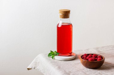 Arka plandaki cam şişede ahududu içeceği. Fotokopi alanı olan dutlu limonata. Yan görünüm.