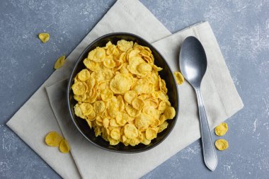 Mavi arka planda siyah kasede mısır gevreği.