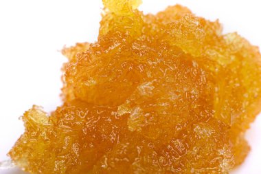 Beyaz arka planda marihuana reçinesi var. Esrar yakın çekim.