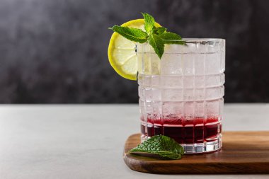 Buzlu, limonlu ve naneli kokteyl. Tahta bir kesme tahtasının üzerinde. Ferahlatıcı bir meyve suyu..