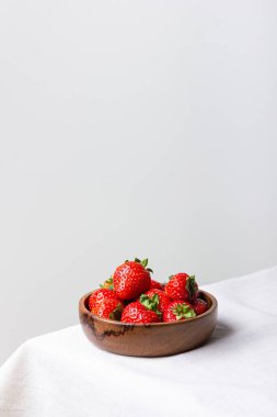 Tahta kasede fotokopi alanı olan taze çilekler. Beyaz masa örtüsü üzerinde tatlı kırmızı böğürtlen. Sağlıklı ve organik tatlı..