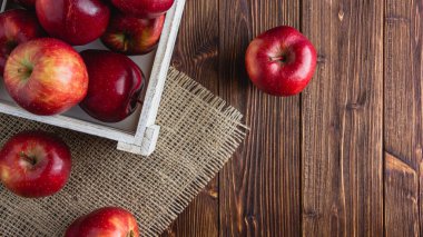 Ahşap bir arka planda kırmızı elmalar. Kopya alanı olan taze meyvelerin üst görünümü.