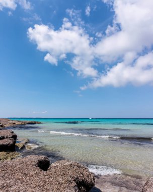 Mallorca adasında vahşi bir sahil manzarası. Mavi güneşli gökyüzü ve beyaz bulutlar.
