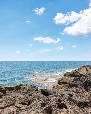 Mallorca adasında vahşi bir sahil manzarası. Mavi güneşli gökyüzü ve beyaz bulutlar.