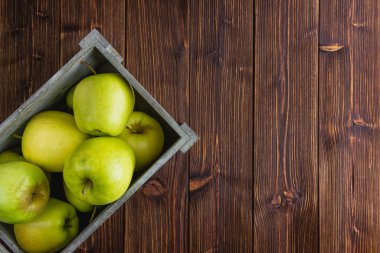 Ahşap bir arka planda sarı elmalar. Kopya alanı olan taze meyvelerin üst görünümü.