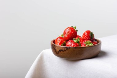 Tahta kasede fotokopi alanı olan taze çilekler. Beyaz masa örtüsü üzerinde tatlı kırmızı böğürtlen. Sağlıklı ve organik tatlı..