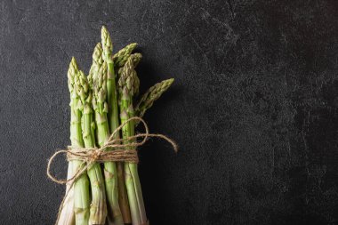 Siyah arka planda yeşil kuşkonmaz ve fotokopi alanı. Taze ve doğal pişmemiş kuşkonmaz. Sağlıklı bitki yiyeceği.