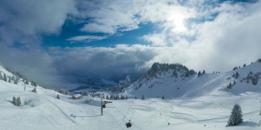 panorama of fresh snow in tyrolean ski resort with ski tracks sky and gondola cabin cable car