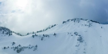 mystical light atmosphere at the hahnenkamm in tyrol with ski tracks, deep in wintry snow