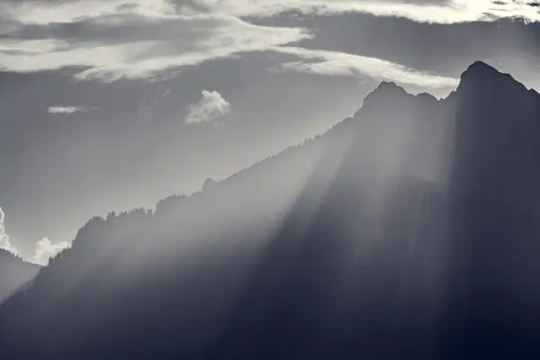 Monocromo Vetas Voluminosas Del Sol Noche Sobre Cresta Las Montañas Imagen De Stock
