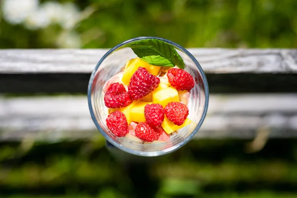 Vista Superior Vertical Yogur Fruta Saludable Con Frambuesas Mango Hoja Imagen de archivo