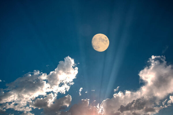 Full moon in blue sky with clouds - fiction