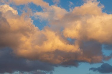 Blue sky with white clouds. The sun shines through the clouds.