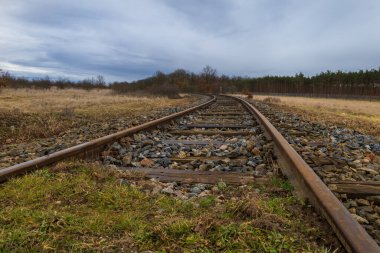 Monoray ile geçen bir manzara. Gökyüzünde ağır kara bulutlar var..