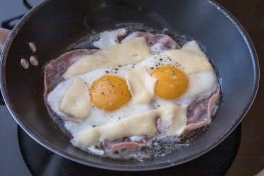 Tavadaki iki yumurtadan heenex. Salamlı ve peynirli yumurta. İyi kahvaltı..