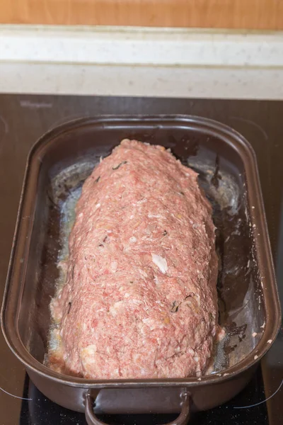 Processed minced meat for meatloaf. Meat in a baking dish.