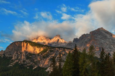 İtalyan Dolomites Tre Cime 'de manzara. Açık mavi bir gökyüzü var ve bir yerlerde bulutlar var..