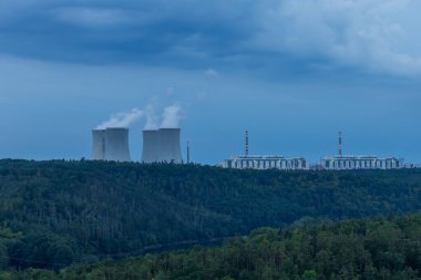 Çek Cumhuriyeti, Avrupa 'daki Dukovany nükleer enerji santrali. Duman soğutma kuleleri. Gökyüzünde bulutlar var. Ön planda İskoçya 'nın doğası var..
