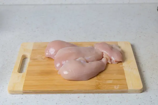 Raw meat - chicken breast on the kitchen table.