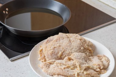 Tavada yağda kızartmak için sarılmış tavuk pirzolası..