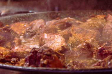 Büyük yuvarlak bir tavada yiyecek ve ızgara tezgahın üzerine konuldu ve markette müşterilere satılması amaçlandı..