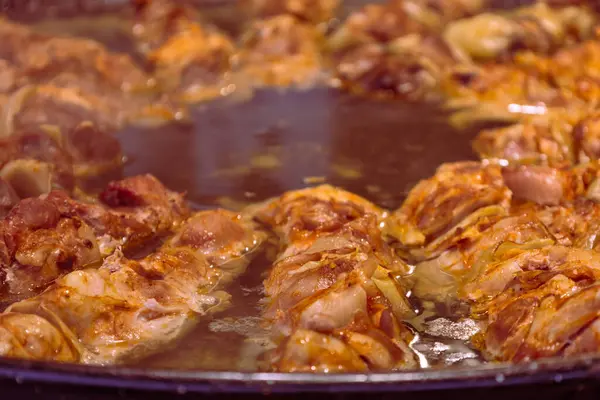 Büyük yuvarlak bir tavada yiyecek ve ızgara tezgahın üzerine konuldu ve markette müşterilere satılması amaçlandı..