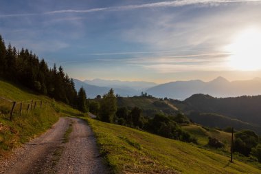 Slovenya 'nın Jamnik köyündeki Aziz Primoz Kilisesi, Avrupa. Kilise dağların yamacında. Gündoğumu, arka planda dağ zirveleri.