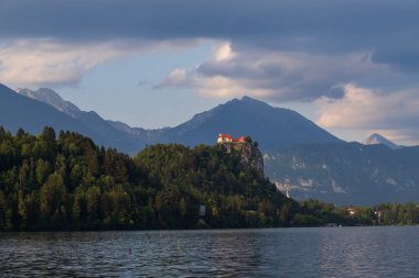 Güzel alp gölü Bled - Slovenya 'da, inanılmaz bir manzara. Göl manzarası, kiliseli ada, Kanlı Kale, dağlar ve bulutlu mavi gökyüzü..