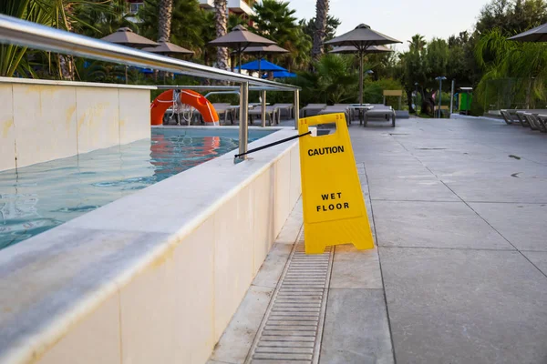 Wet pool floor warning. Yellow warning sign with the words wet floor.