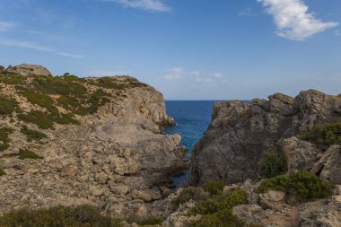 Deniz manzarası - Rodos adasındaki kayalar ve yeşil bitkilerin manzarası.