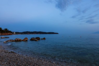 Yunanistan 'ın Thassos adasındaki akşam oteli plajı. Sahilde şemsiyeler ve güneşlikler var.