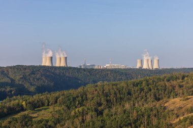 Çek Cumhuriyeti, Avrupa 'daki Dukovany nükleer enerji santrali. Duman soğutma kuleleri. Gökyüzünde bulutlar var. Ön planda İskoçya 'nın doğası var.