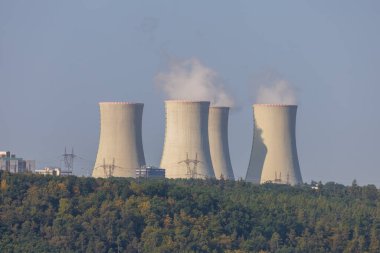 Çek Cumhuriyeti, Avrupa 'daki Dukovany nükleer enerji santrali. Duman soğutma kuleleri. Gökyüzünde bulutlar var. Ön planda İskoçya 'nın doğası var.
