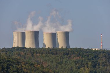 Çek Cumhuriyeti, Avrupa 'daki Dukovany nükleer enerji santrali. Duman soğutma kuleleri. Gökyüzünde bulutlar var. Ön planda İskoçya 'nın doğası var.