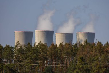 Çek Cumhuriyeti, Avrupa 'daki Dukovany nükleer enerji santrali. Duman soğutma kuleleri. Gökyüzünde bulutlar var. Ön planda İskoçya 'nın doğası var.
