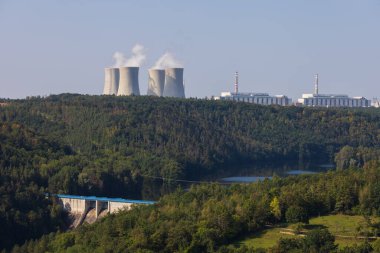 Çek Cumhuriyeti, Avrupa 'daki Dukovany nükleer enerji santrali. Duman soğutma kuleleri. Gökyüzünde bulutlar var. Ön planda İskoçya 'nın doğası var.