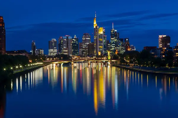Fotoğraf: Frankfurt 'taki Deutschherren Köprüsü' nden. Gün batımından sonra mavi saatte. Şehir merkezi ve nehir arka planda yanıyor.